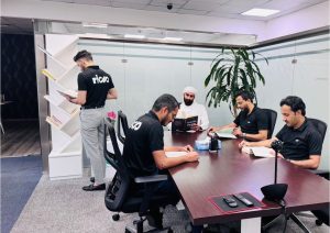 RIDA team members reading and collaborating in a modern office meeting room